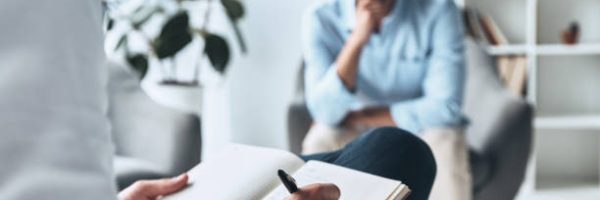 Young frustrated man solving his mental problems while having therapy session with psychologist