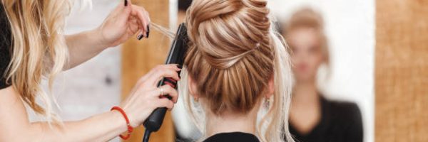 business woman lady boss in beauty salon making hairdress and looking to the mirror