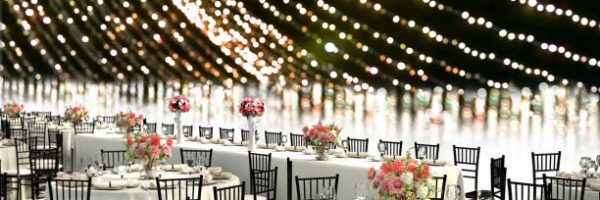 3D Illustration of a wedding reception venue decorated in white with ten seat round tables and a head table on a bokeh background