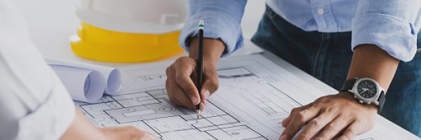 engineer meeting for an architectural project. working with partner and engineering tools working on blueprint architectural project at the construction site at desk in the office.