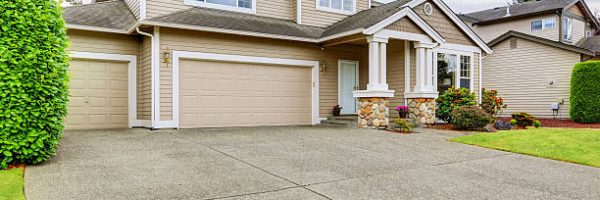 Neat beige home with two garage spaces and large concrete driveway. Northwest, USA