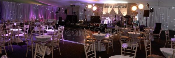 party-venue-lounge-ballroom-tables-stage-colorful-lighting-128700051